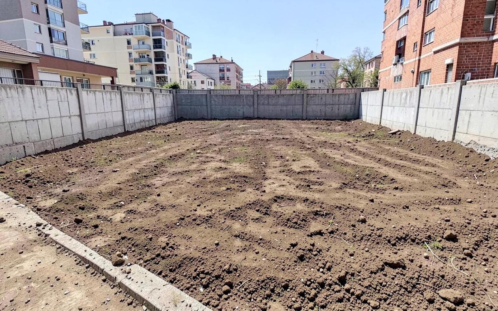 Freshly cleared and graded urban plot with compacted soil, ready for new construction